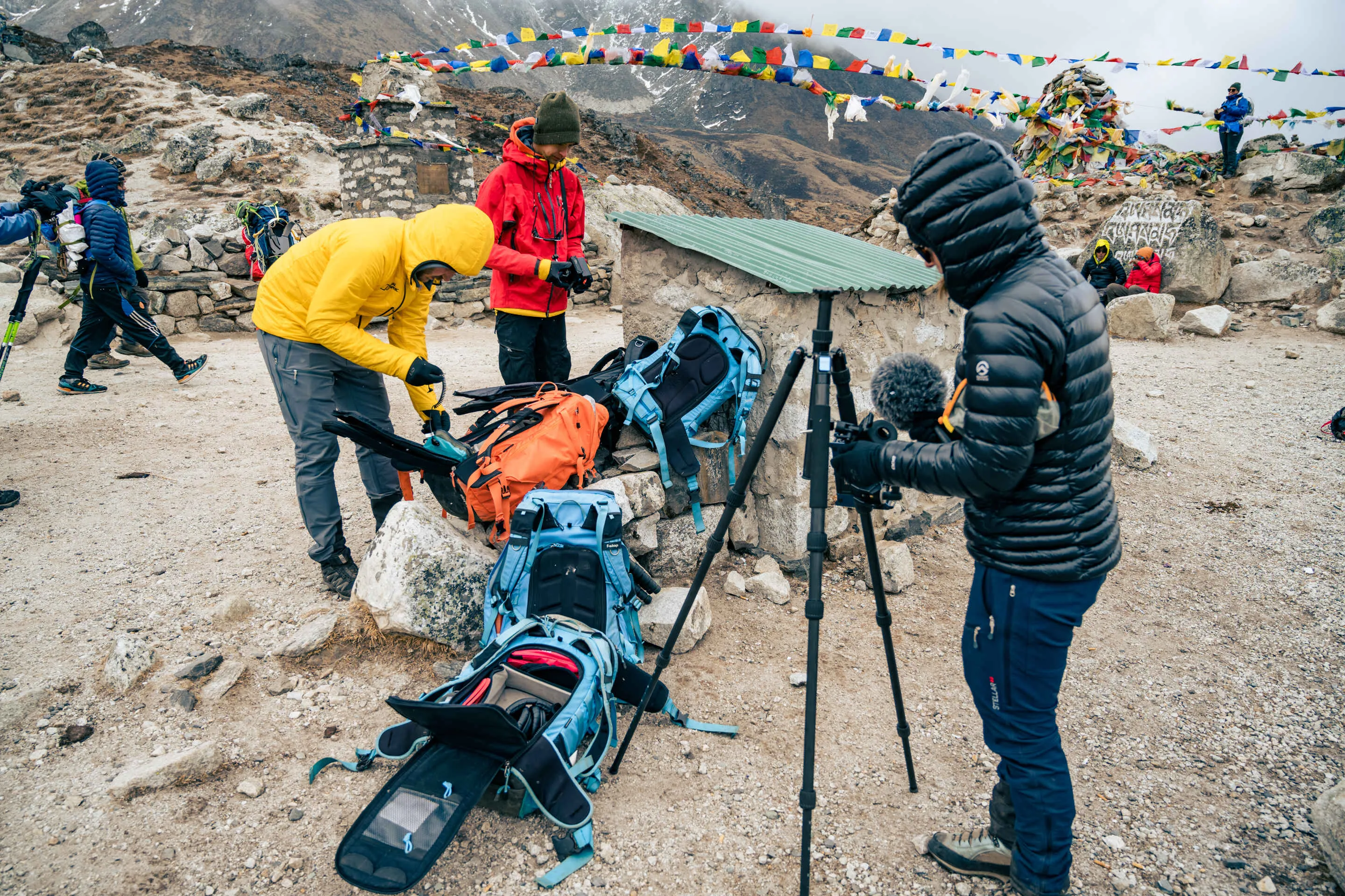 Camp setup with prayer flags and mountain backdrop