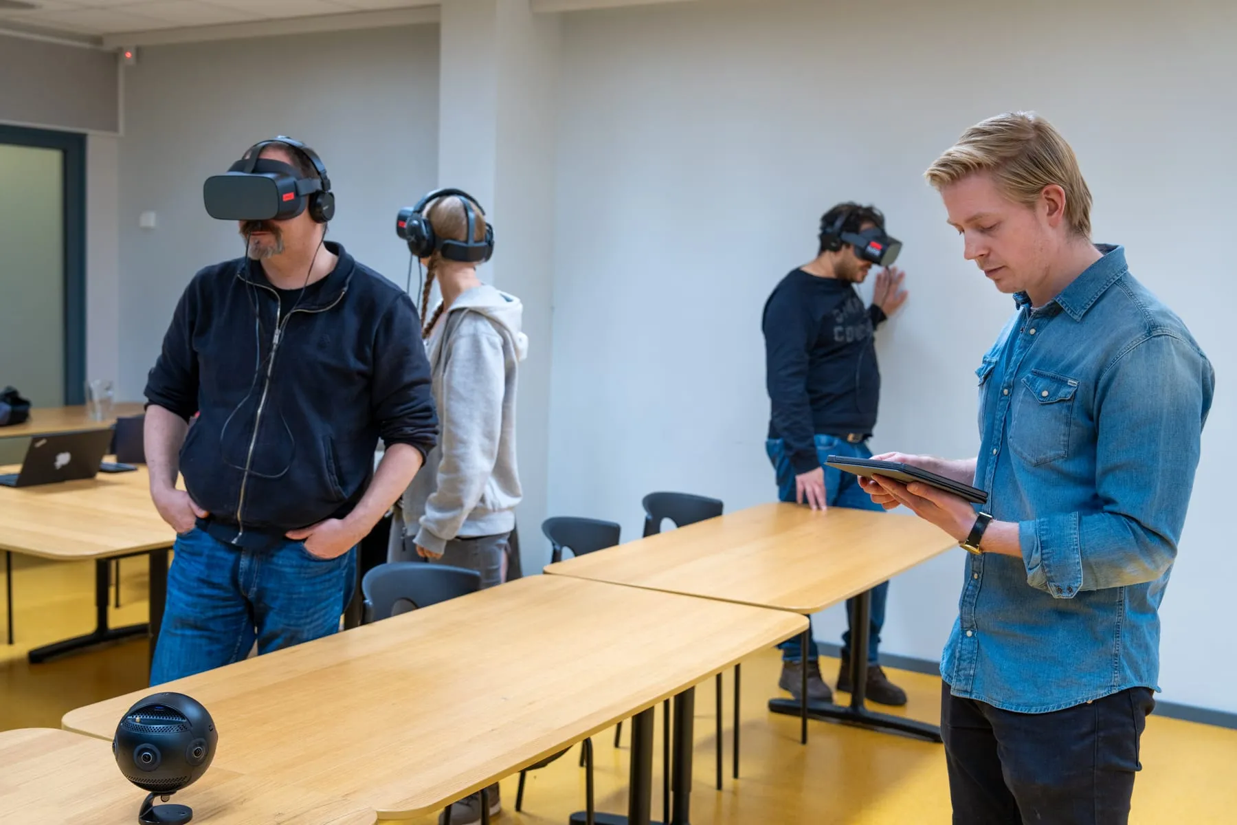 Workshop participants trying VR headsets while an instructor runs the session from a tablet
