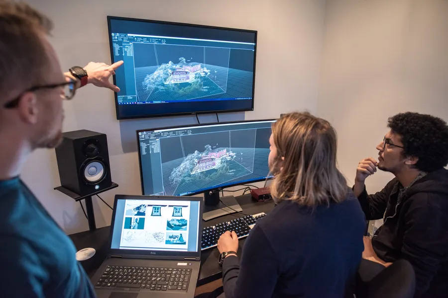 Tre deltagare arbetar med en 3D-skanning på två skärmar under en workshop